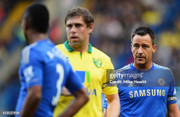 John Terry and Ashley Cole of Chelsea look on as they mark Grant Holt of Norwich City during the Barclays Premier League match between Chelsea and...