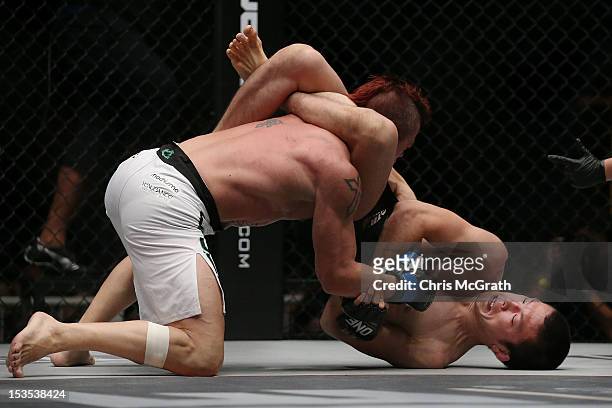 Shinya Aoki of Japan chokes out Arnaud Lepont of France during the One Fighting Championship Super Fight at Singapore Indoor Stadium on October 6,...