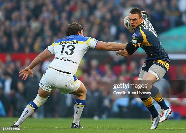 Kevin Sinfield of Leeds Rhinos is challenged by Ben Harrison of Warrington Wolves during the Stobart Super League Grand Final between Warrington...