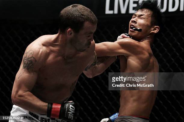 Jens Pulver of the USA connects with a left hand punch dislodging the mouth guard of Zhao Ya Fei of China during the One Fighting Championship,...