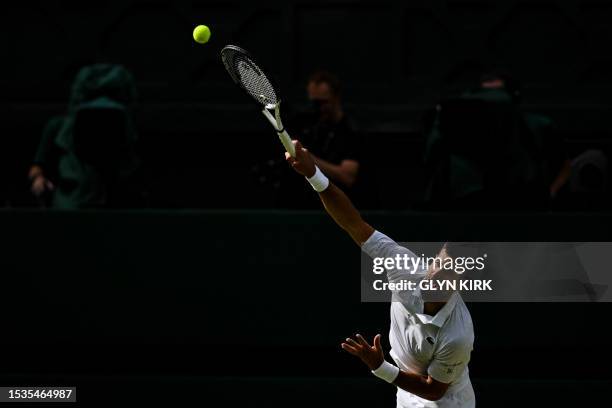 Serbia's Novak Djokovic serves against Spain's Carlos Alcaraz during their men's singles final tennis match on the last day of the 2023 Wimbledon...