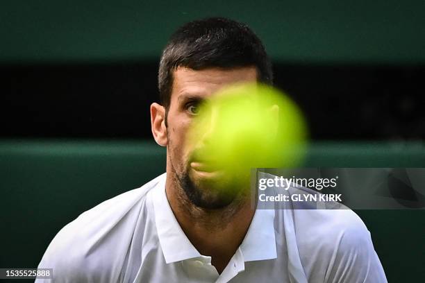 Serbia's Novak Djokovic stares at the ball prior to playing a return against Spain's Carlos Alcaraz during their men's singles final tennis match on...