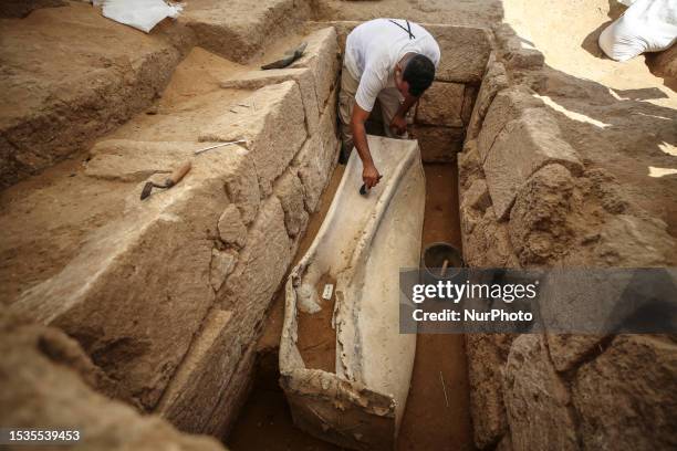 Palestinian archaeologist works on a lead sarcophagus on July 16 the second to be unearthed at a Roman-era necropolis discovered in Gaza city in...
