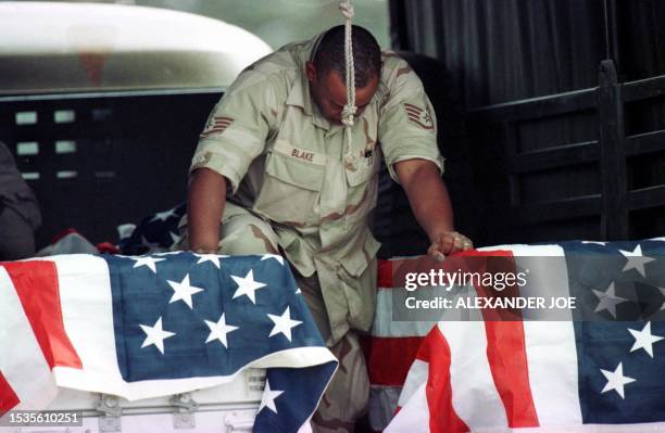 Marine bows his head 10 August in Nairobi as he says farewell to the bodies of 11 US nationals who where killed by a bomb blast near the US embassy...