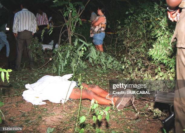 Un policia monta guardia frente al cadaver de uno de los 6 jovenes asesinados en Cali, 500 kms al suroeste de Bogota, 10 de Julio. Los cadaveres de...