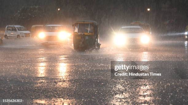 Commuters out during a heavy rain spell, at Mandi House on July 15, 2023 in New Delhi, India.
