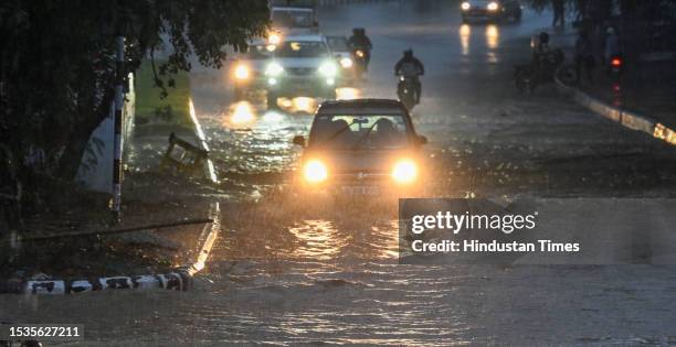 Commuters out during a heavy rain spell, at Bhairon Marg near Pragati Maiden on July 15, 2023 in New Delhi, India.