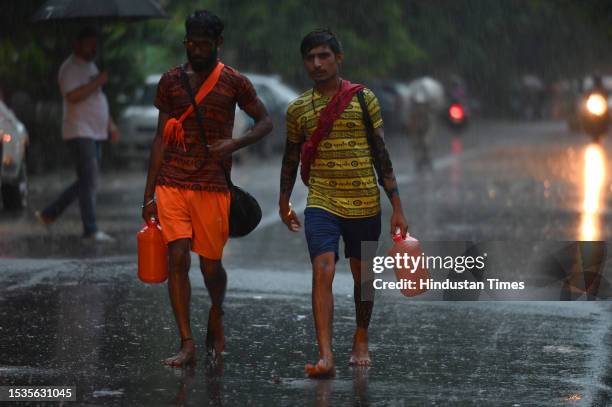 Commuters seen out during light rains at Sector 12 road, on July 15, 2023 in Noida, India.