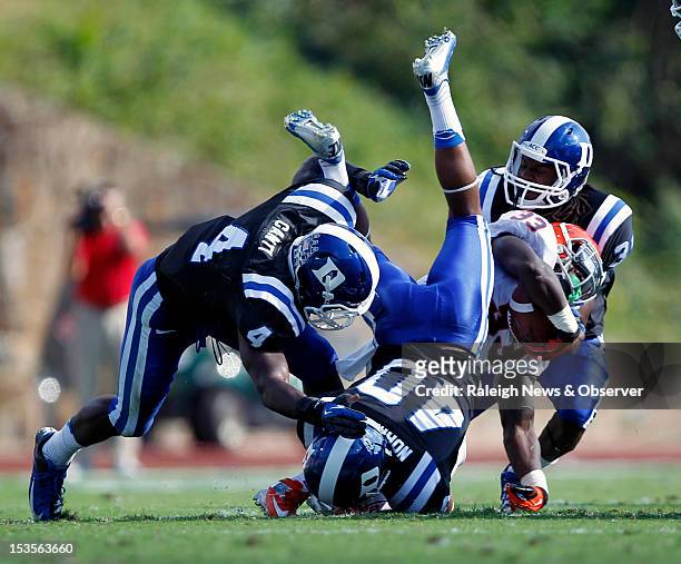 Duke defensive backs Walt Canty , Dwayne Norman and Tony Foster take down Virginia running back Perry Jones during the second quarter at Wallace Wade...