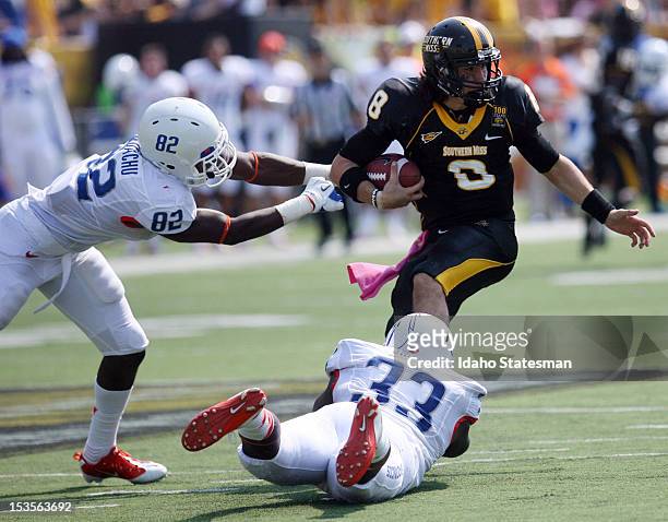 Boise State defensive end Samuel Ukwuachu and linebacker Tommy Smith tie up Southern Miss quarterback Ricky Lloyd during game action at Roberts...