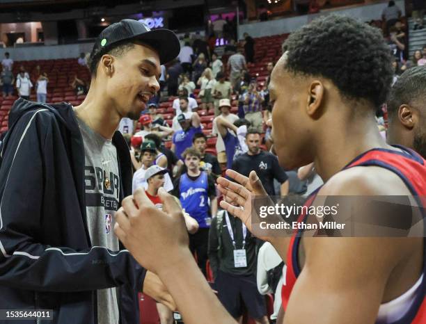 Victor Wembanyama of the San Antonio Spurs greets his former Boulogne-Levallois Metropolitans 92 teammate, Bilal Coulibaly of the Washington Wizards,...