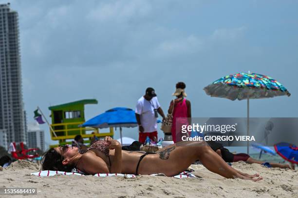 Beachgoers enjoy sunbathing during during an intense heat wave in Miami Beach on July 16, 2023. The National Weather Service warned of an "extremely...