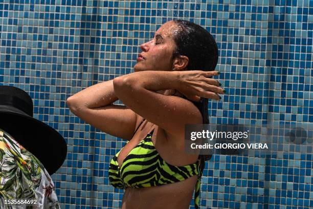 Woman rinses off after going to the beach during during an intense heat wave in Miami Beach on July 16, 2023. The National Weather Service warned of...