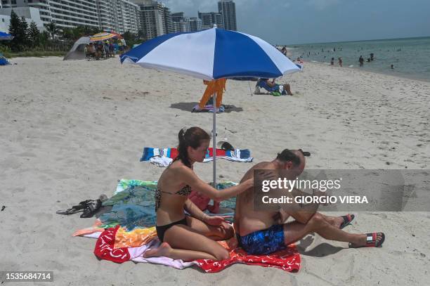 Beachgoers enjoy sunbathing during during an intense heat wave in Miami Beach on July 16, 2023. The National Weather Service warned of an "extremely...