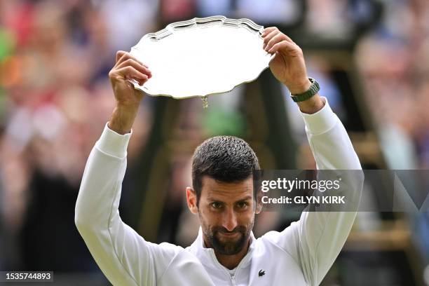 Serbia's Novak Djokovic raises the runner-up's trophy after being defeated by Spain's Carlos Alcaraz during their men's singles final tennis match on...