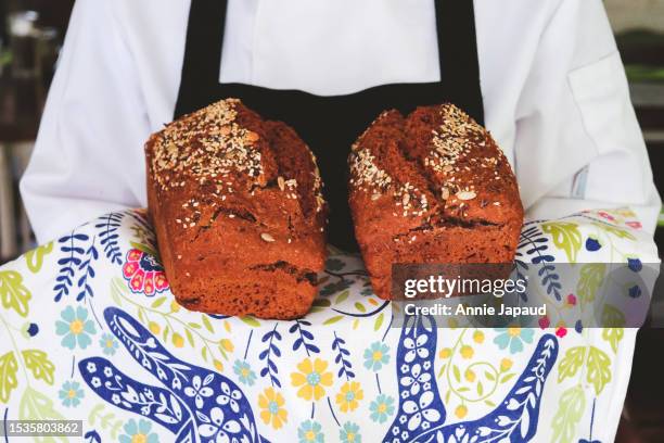 front view and close up of baker holding two brown soda breads - galway people stock pictures, royalty-free photos & images