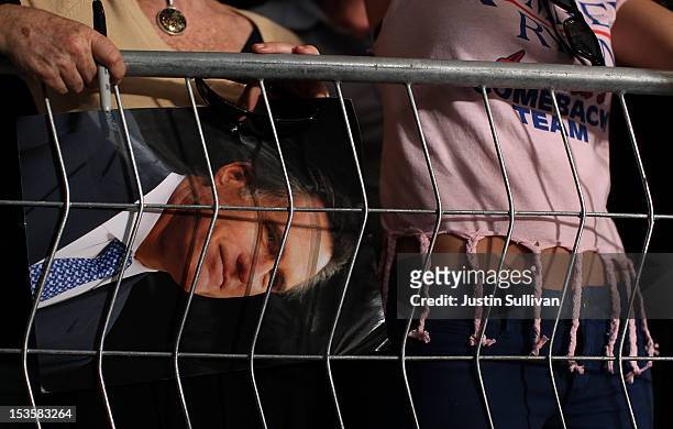 Supporter holds a photograph of Republican presidential candidate, former Massachusetts Gov. Mitt Romney during a campaign rally on October 6, 2012...