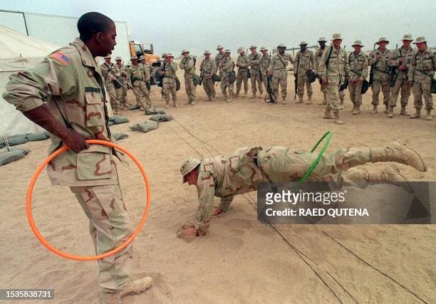 Soldiers have fun with hoola-hoops during Christmas celebrations in the Kuwaiti desert, some 45 kilometers from the Iraqi border, 25 December. The US...