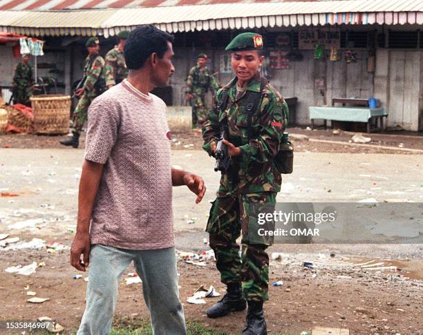 An Indonesian soldier points his assault rifle at an Acehnese man after fresh riots broke out in Geudong, some 6kms southeast of Lhokseumawe in the...