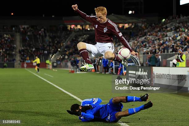 Jeff Larentowicz of the Colorado Rapids leaps over a sliding Steven Beitashour of the San Jose Earthquakes as they battle for control of the ball at...