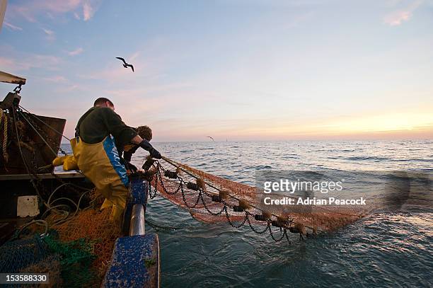 trawler fishing at night - fishing net stockfoto's en -beelden