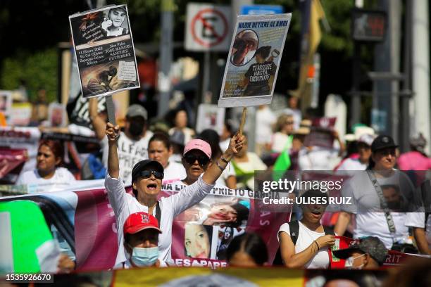 Relatives of missing persons hold signs with photos of their loved ones during a march against the government's ban on searches for the disappeared,...