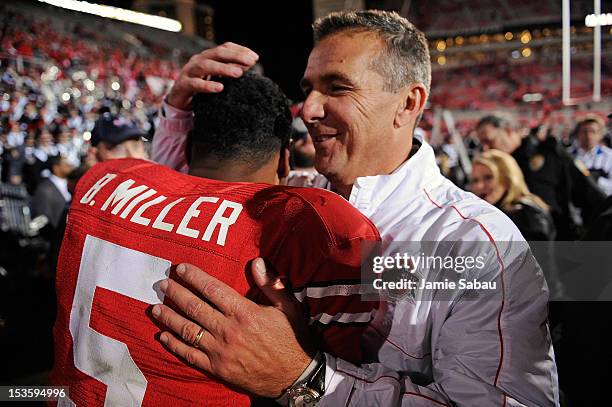 Head Coach Urban Meyer hugs quarterback Braxton Miller of the Ohio State Buckeyes after the Buckeyes defeated the Nebraska Cornhuskers 63-38 at Ohio...