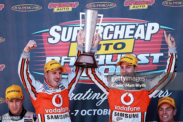 Paul Dumbrell and Jamie Whincup drivers of the Team Vodafone Holden hold aloft the Peter Brock Trophy after winning the Bathurst 1000, which is round...