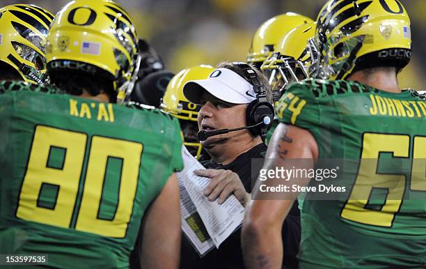 Head coach Chip Kelly of the Oregon Ducks speaks with his team during a timeout during the third quarter of the game against the Washington Huskies...