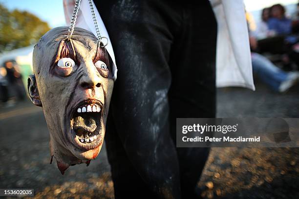 Visitor to the Shocktober Fest at Tulleys Farm carries a zombie head on October 6, 2012 in Turners Hill, England. People dressed as zombies from...