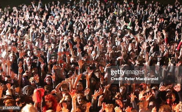 Visitors to the Shocktober Fest dressed as zombies raise their hands in unison at Tulleys Farm on October 6, 2012 in Turners Hill, England. People...