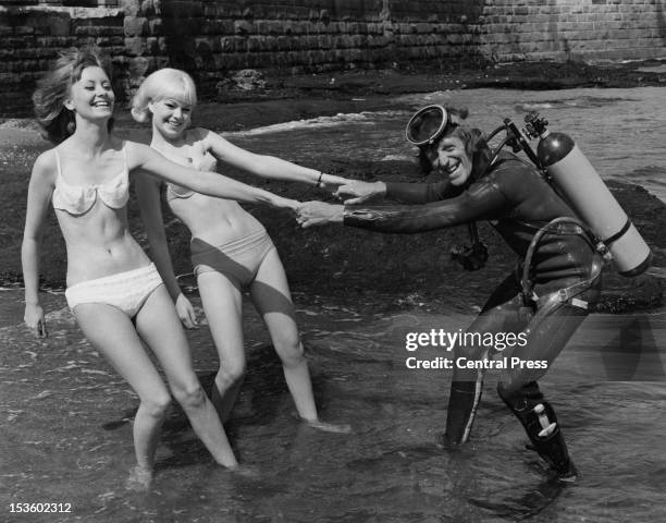 English disc jockey and TV presenter Jimmy Savile , with his secretaries, Barbara Counsel and Christine McCarthy, on the beach at Scarborough,...