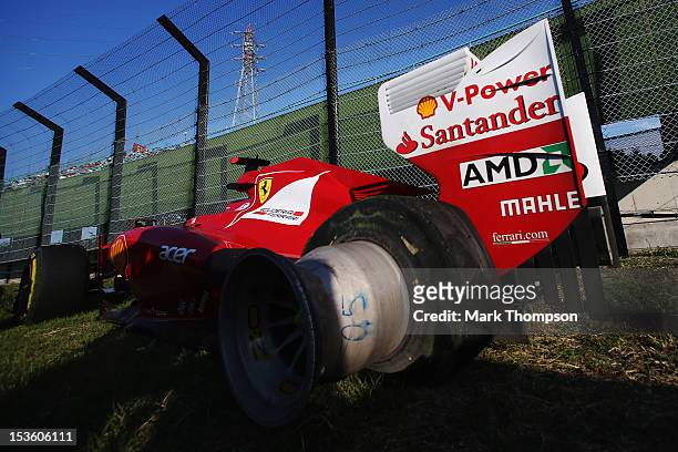 The damaged car of Fernando Alonso of Spain and Ferrari is seen following his retirement after spinning out at the first corner at the start of the...