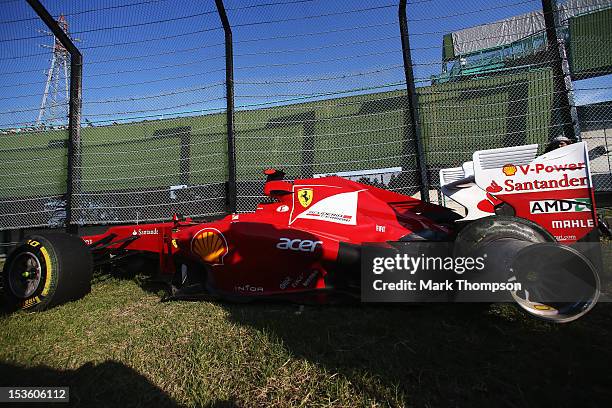 The damaged car of Fernando Alonso of Spain and Ferrari is seen following his retirement after spinning out at the first corner at the start of the...