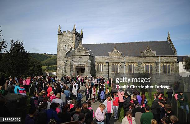 Members of the community of Machynlleth stand in the church yard of St Peter's Church for a service with prayers for missing five-year-old April...