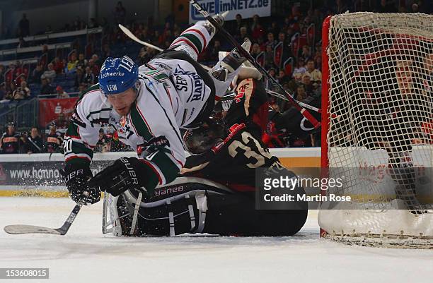 Dimitri Paetzold , goaltender of Hannover stops Patrick Seifert of Augsburg battle in front of the net during the DEL match between Hannover...