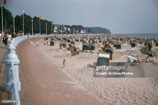 Tourists and beach seats at Travemunde in Lubeck, Germany, circa 1970. The beach is at the mouth of the river Trave on the Baltic Sea.