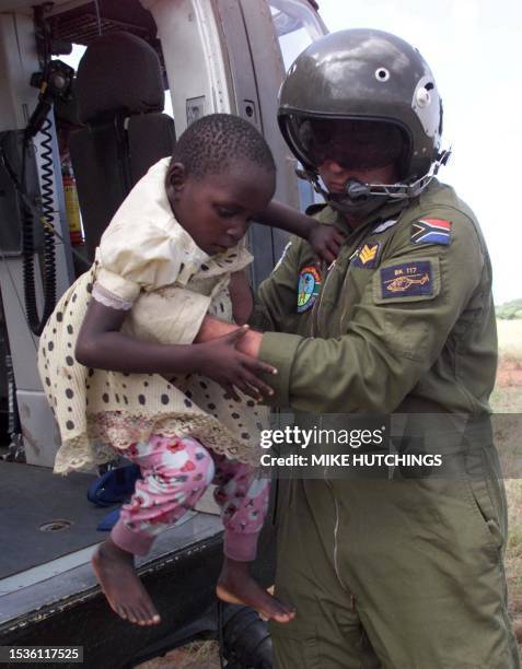 Child is helped off a helicopter 04 March 2000 in Chibuto after being rescued from a tree with seven other flood victims near Chokwe on the Limpopo...