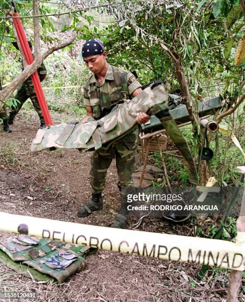 Combat engineer from Ejercito, Nicaragua gards his equipment from working 28 January, 2000 after finding and dismantling landmines 270km east of the...