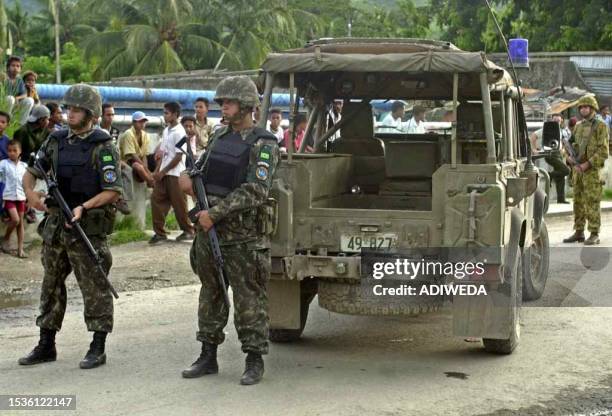 Two INTERFET soldiers block a street in the Bairopite quarter of Dili 19 January 2000 after clashes between members of the Conselho National...