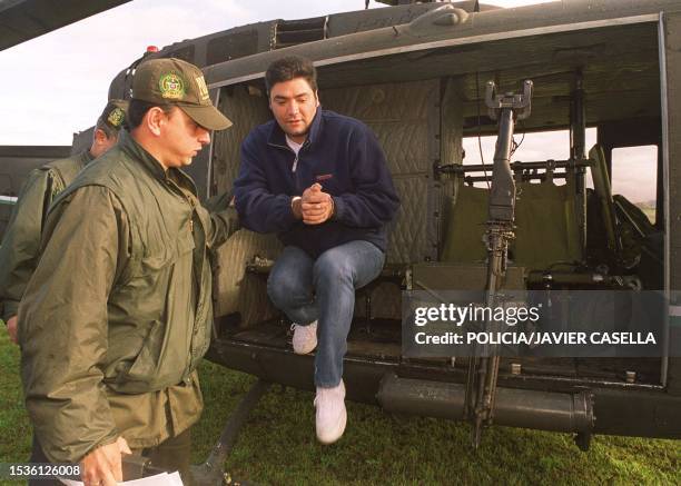 Suspected drug trafficker Jaime Lara Nausa is assisted by a soldier at the Bogota airport as he is extradicted to the US 21 November 1999. El...