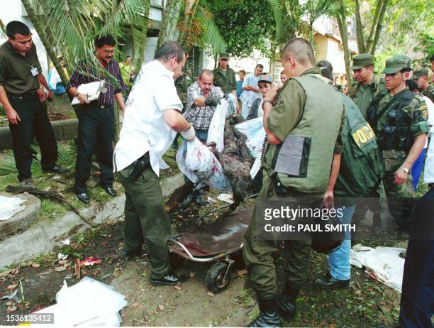Military personnel remove the body of one of ten victims of a car bombing 30 July in Medellin, Colombia. The bomb targeted an anti-kidnapping unit an...