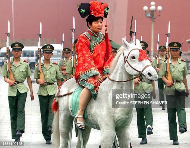 Chinese tourist, dressed in Imperial garb and mounted on a stuffed steed appears oblivious to soldiers marching behind with their bayonettes, 04 June...