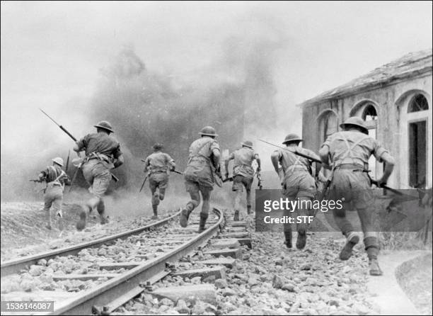 Photo prise en août 1943 de troupes britanniques de la 8ème Armée, sous le commandement du général Montgommery, avançant lors de combats en Sicile,...