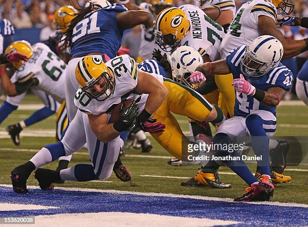 John Kuhn of the Green Bay Packers scores a touchdown between Mario Harvey and Antoine Bethea of the Indianapolis Colts at Lucas Oil Stadium on...
