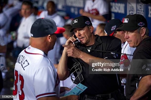 Home plate umpire Jeff Kellog talks with Atlanta Braves manager Fredi Gonzalez in the dugout after a controversial infield fly rule call in the...