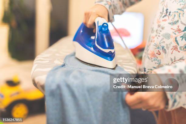 woman ironing - ironing board imagens e fotografias de stock