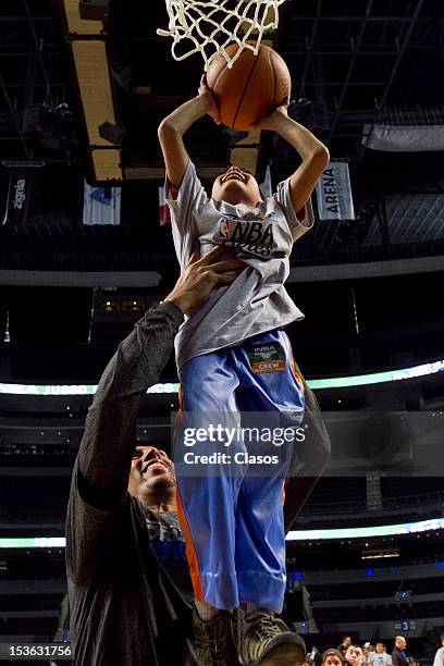 Player Gustavo Ayon plays with a kid during a training session of New Orleans Hornets and Orlando Magic with disabled people at Arena on October 06,...