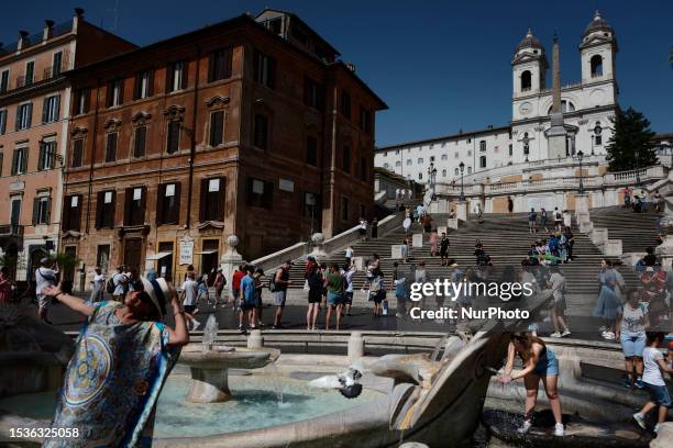 People cool off during an ongoing heat wave with temperatures reaching 40 degrees, at Piazza di Spagna, on July 16, 2023 in Rome, Italy.