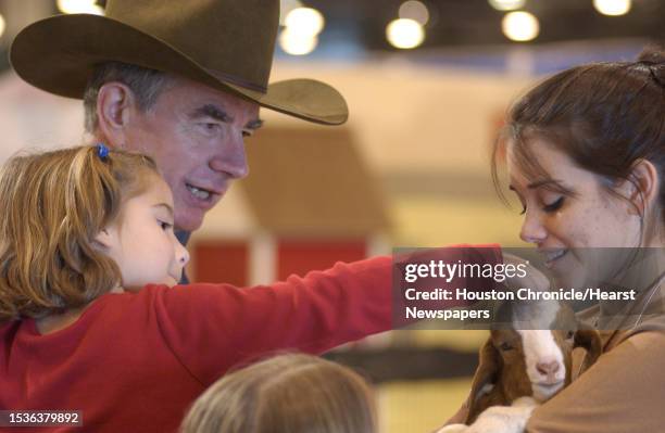 Shannon Skillman pets a goat held by Victoria Trice, an Ag Journalism and Ag Science major at Texas A&M University. Shannon is held by her...